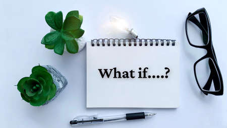 What if text on notepad with light bulb, pen and plant background.の写真素材
