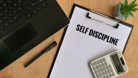 Business motivational words - Self Discipline on a piece of paper. With laptop, pen, calculator and brown table background.の写真素材