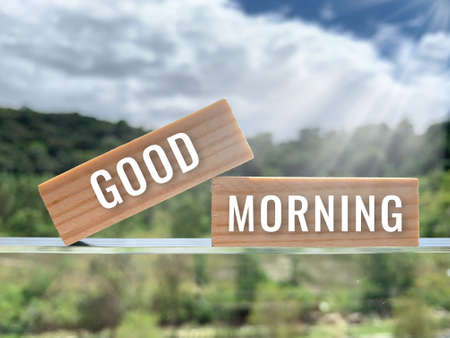 Good Morning text on wooden blocks with bright sun background. Morning greeting concept.の写真素材