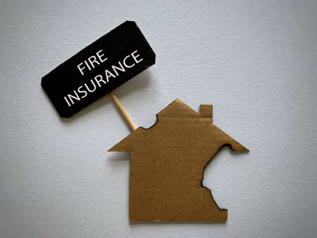 Fire insurance text with burnt model house background.の写真素材