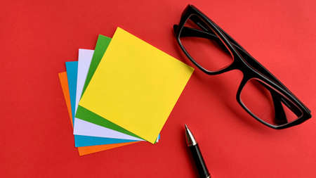 Top view copy space. Sticky notes, glasses and red background. Copy space conceptの写真素材