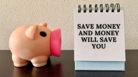 Save money and money will save you text on notepad with piggy bank background.の写真素材