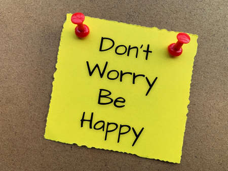 Do not worry be happy text on yellow torn notepad.の写真素材