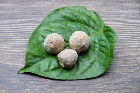 Betel nut with betel leaf isolated on wooden background. Food concept and copy spaceの写真素材