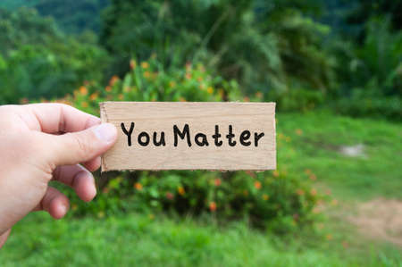 Hand holding wooden banner with text - You matter. Motivational conceptの写真素材