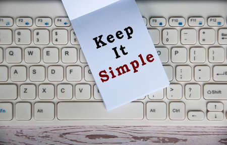 Top view of Keep it simple text on notepad on top of keyboard.
