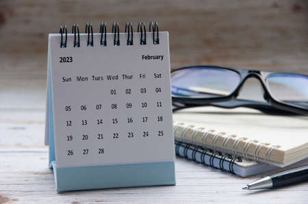 February 2023 white desk calendar with notepad and glasses background. New year concept and copy spaceの写真素材