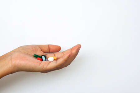 Female hand holding assorted pills with customizable space for text or ideas. Copy space and Medical conceptの写真素材