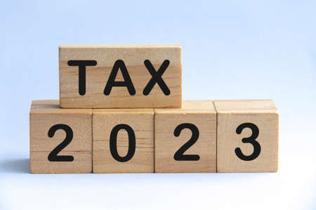 Tax 2023 text on wooden blocks with white background. 2023 tax conceptの写真素材