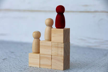Wooden red figure leading others on top of wooden blocks. Career growth and leadership concept.の写真素材
