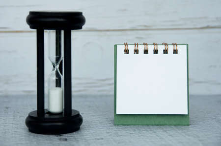 Blank notepad with minutes glass with customizable space for text or ideas. Copy spaceの写真素材