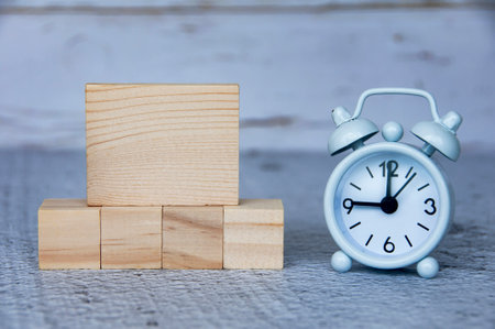 Blank wooden blocks and alarm clock with customizable space for ideas or text. Copy space