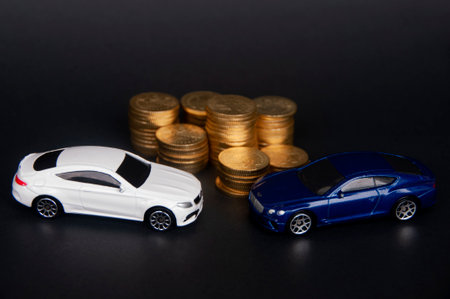 Kuala Lumpur, Malaysia - July 2022 : Miniature toy car of Mercedes AMG and Bentley Continental GT with gold coins on black cover background. Wealth conceptのeditorial素材