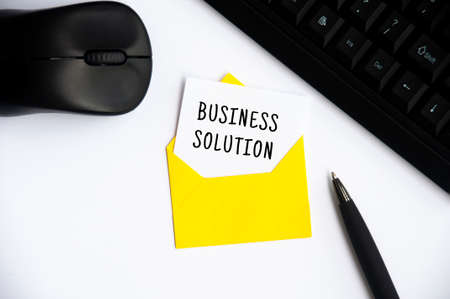 Business solution on notepad in an envelope with laptop and mouse on white background. Business conceptの写真素材