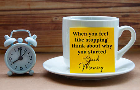 Motivational quote text on yellow notepad on coffee cup - When you feel like stopping think about...