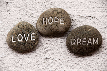 Love, hope and dream text engraved on stones. Life concept.の写真素材