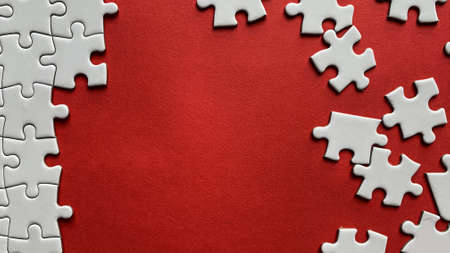 Jigsaw puzzle on red background with customizable space for text or ideas. Copy space.の写真素材