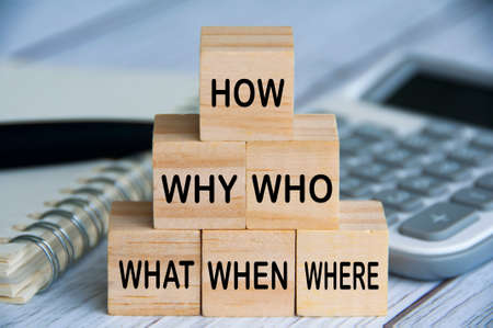 How, why, who, what, when and where text on wooden blocks with calculator, pen and notebook background. Solution conceptの写真素材