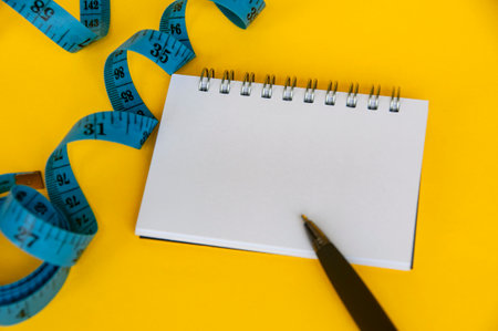 Blank notepad and blue measuring tape with customizable space for text or ideas. Copy space and...