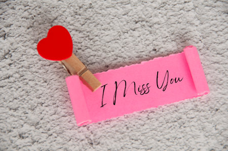 I miss you text on torn pink paper. Romance and relationship concept.の写真素材