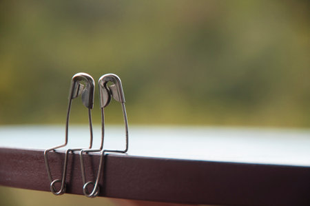 Safety pin couple sitting on table with customizable space for text and ideas. Love and romance...