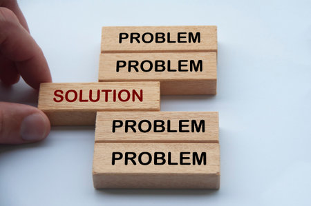 Hand putting wooden block with word solution in the middle of wooden blocks with words problem. Solution concept.の写真素材