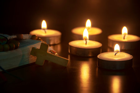 Holy Rosary and Bible on dark candlelight background with customizable space for text or ideas. Copy...