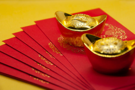 Chinese New Year packets with Gold Ingots on yellow background. With customizable space for text.