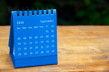 September 2023 blue desk calendar on wooden table background with customizable space for text. Copy space.の写真素材