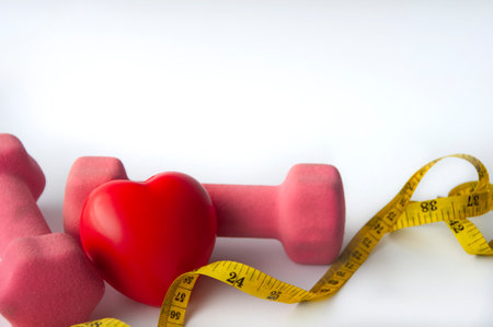 Heart shape with dumbbell on white background cover. Weight loss conceptの写真素材