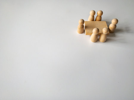 Wooden people figures having business meeting with customizable space for text. Copy space.の写真素材