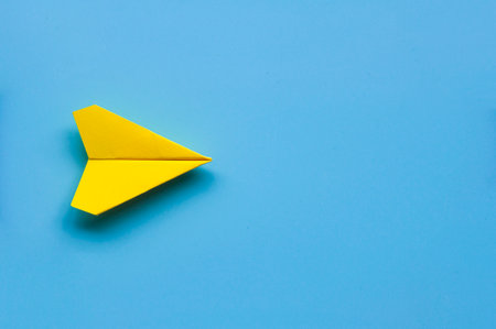 Top view of single yellow paper airplane with customizable space for text.