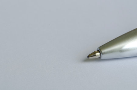 Close-up of silver pen on white notepad with customizable space for text or ideas