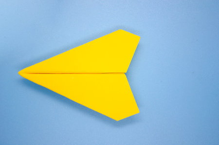 Top view of yellow airplane on light blue background with customizable space for text. Copy space and airplane concept.の写真素材