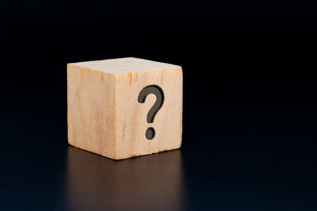 Question mark engraved on wooden cube with dark background. Question and Answer sessionの写真素材