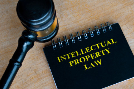 Top view of black notebook with text Intellectual Property Law and with gavel backgroundの写真素材