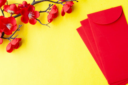 Top view of Chinese New Year red packet and cherry blossom with customizable space for text or wishes.の写真素材