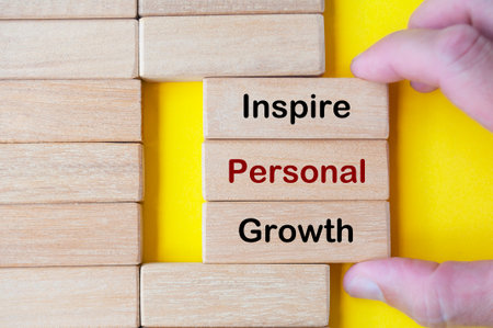Hand pulling wooden blocks with Inspire Personal Growth text on wooden blocks. inspirational concept.