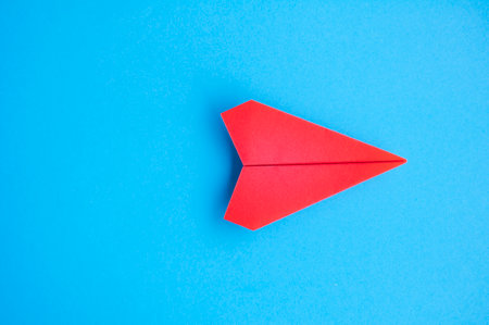 Top view of red paper airplane with customizable space for text or ideas.の写真素材