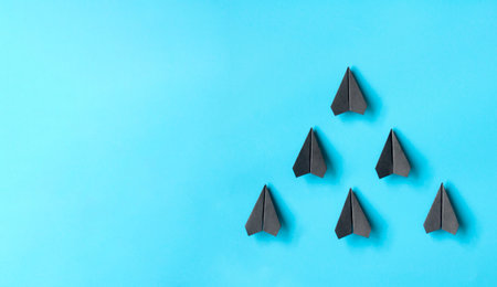 Black paper airplane origami leading the rest of the airplanes with customizable space for text.