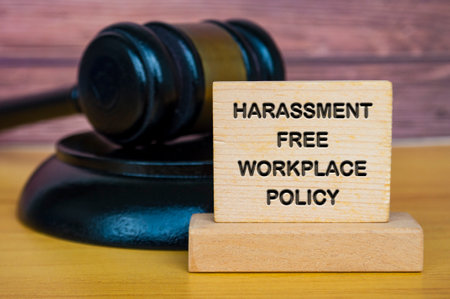 Harassment free workplace policy engraved on wooden block with Lawyer gavel background.の写真素材