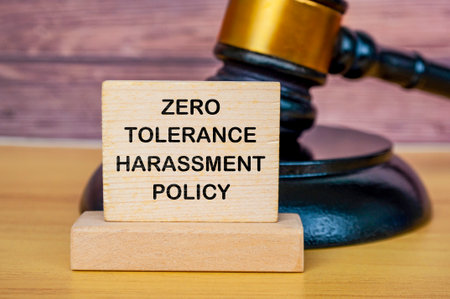 Zero tolerance harassment policy text written on wooden board with lawyer's gavel background.の写真素材