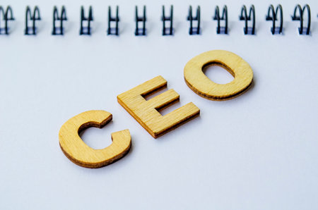 Top view of CEO wooden letters on white notepad. CEO representing Chief Executive Officerの写真素材