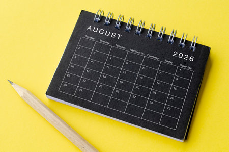 Top view of August 2026 calendar on black notepad with yellow background. Calendar concept.の写真素材
