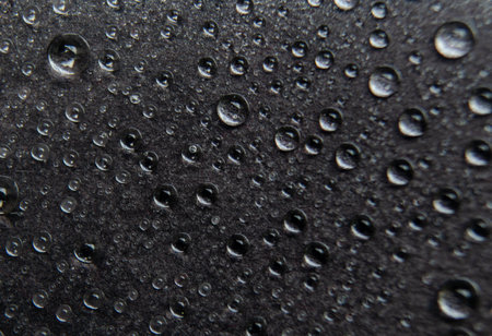 Close up of water droplets on dark cover background. Water droplets and wallpaper design concept.の写真素材