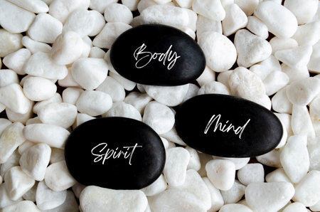 Mind, Body and Spirit text on black zen stones. Meditation and peace concept