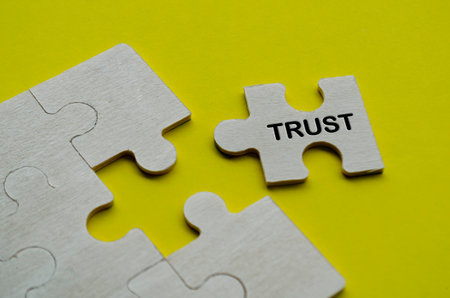 Trust text on wooden separated wooden jigsaw puzzle. Team work and trust concept.