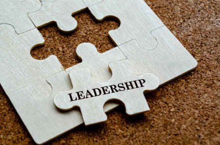 Leadership text on wooden separated wooden jigsaw puzzle. Leadership and team work concept.