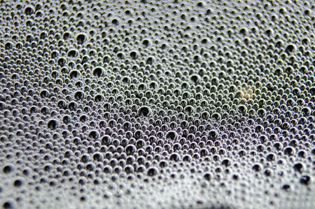Soap bubbles forming patterns on a textured surface. Suitable for wallpaper background or design.の写真素材