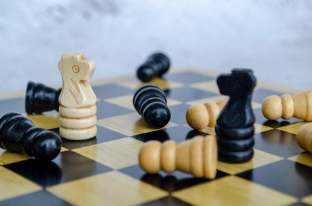 Chess board game with black and white wooden figures on it.の写真素材